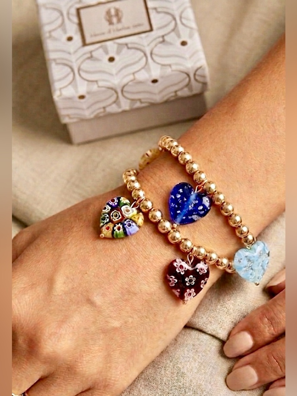 New in box. Stretchy beaded bracelet with 5 millefiori heart charms in colors